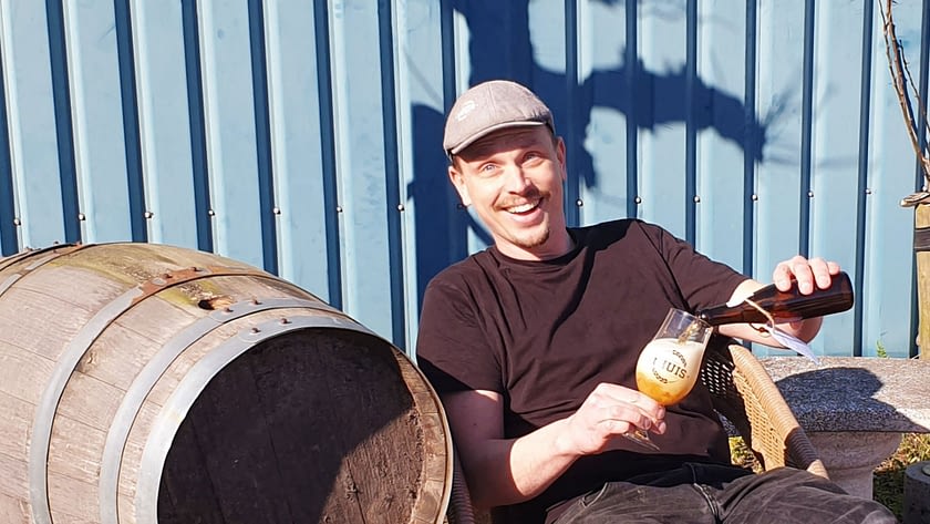 eigenaar Mark zit op het terras een biertje van zijn eigen ambachteljike brouwerij tHuis in te schenken in Midden-Delfland