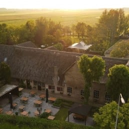 luchtfoto van de boerderij waarin Brasserie Oostgaag gevestigd is midden tussen de weilanden en in de polder van Midden-Delfland