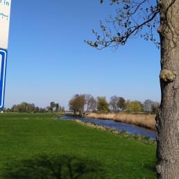bord met stiltegebied aan een paal middenin Midden-Delfland met in de achtergrond weilanden in het polderlandschap op een zonnige dag