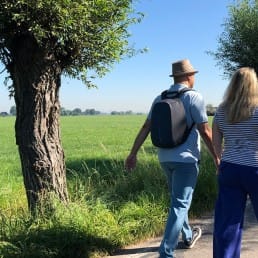 wandelaar wandelen in de Zouteveense polder tussen de weilanden en de knotwilgen op een zonnige dag in Midden-Delfland