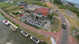 luchtfoto van het pand en terras van eetcafe de bonte haas en de luxe en comfortabele sloepen die voor het terras in het water liggen in het Westland