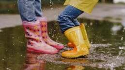Buitenspelen kinderen laarzen in de regen