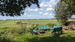 vuurplaats bij Buitengoed Ta Fête met uitzicht over de groene polder van Midden-Delfland en blauwe lucht met witte wolkjes op een zonnige dag