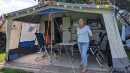 Anjo Vonk uit Vlaaardingen stat voor haar tent op Camping Bouwlust in Midden-Delfland in de zomer van 2023